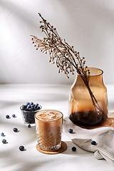 Image showing glass of ice coffee, brown sugar and blueberries