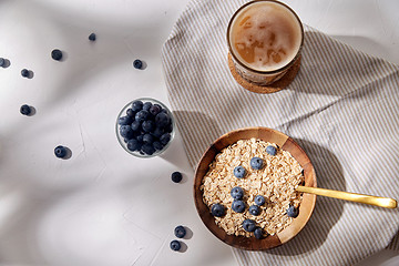 Image showing oatmeal with blueberries, spoon and coffee