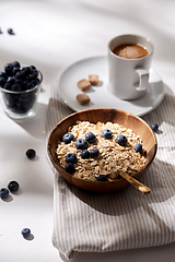 Image showing oatmeal with blueberries, spoon and cup of coffee