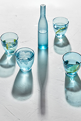 Image showing glasses with water and lemons on white background