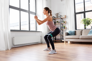 Image showing woman exercising with resistance band at home