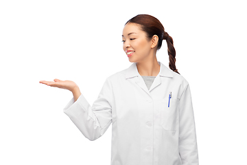 Image showing asian female doctor holding something on hand