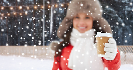 Image showing happy woman with coffee cup over winter ice rink