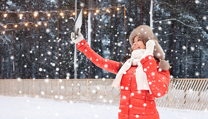 Image showing woman in winter fur hat with tablet pc at ice rink