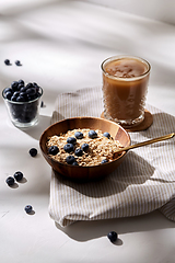 Image showing oatmeal with blueberries, spoon and coffee