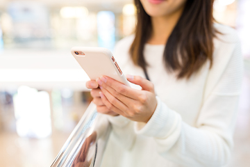 Image showing Woman sending sms on cellphone