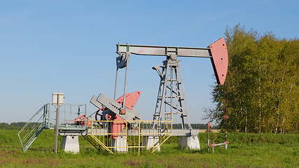 Image showing Operating oil and gas well in oil field, profiled against the blue sky