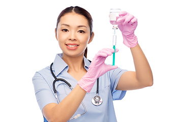 Image showing happy asian female nurse with medicine and syringe
