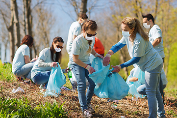 Image showing volunteers with garbage bags cleaning park area