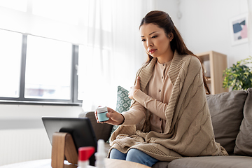 Image showing sick woman with medicine has video consultation