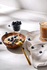 Image showing oatmeal with blueberries, spoon and coffee