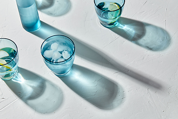 Image showing glasses with water and lemons on white background