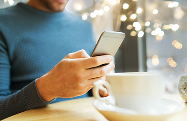 Image showing close up of man with smartphones at cafe