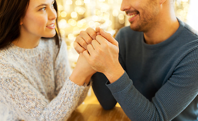 Image showing happy couple holding hands at restaurant or cafe