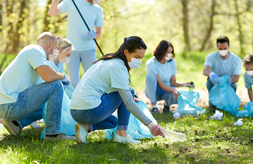 Image showing volunteers in masks cleaning park from garbage