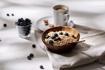 Image showing oatmeal with blueberries, spoon and cup of coffee