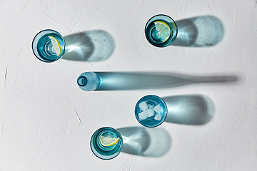 Image showing glasses with water and lemons on white background