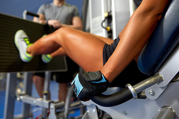 Image showing woman flexing muscles on leg press machine in gym