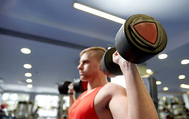 Image showing close up of man with dumbbells exercising in gym