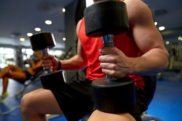 Image showing close up of man with dumbbells exercising in gym