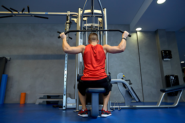 Image showing close up of man exercising on cable machine in gym