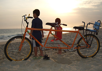 Image showing double bike on the beach sand