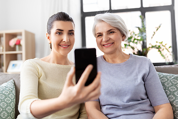 Image showing senior mother with daughter taking selfie at home
