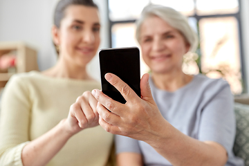 Image showing daughter and senior mother with smartphone at home