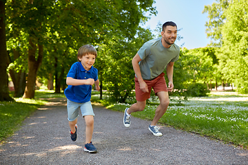 Image showing happy father and son compete in running at park