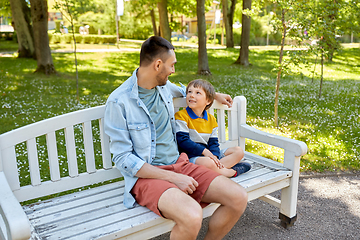 Image showing father with son sitting on park bench and talking