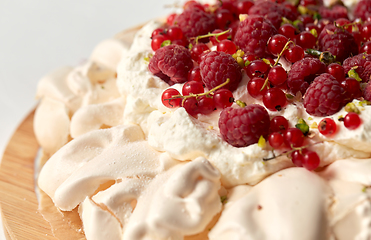 Image showing pavlova meringue cake with berries on wooden board