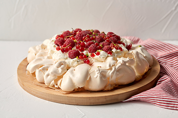 Image showing pavlova meringue cake with berries on wooden board