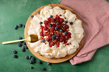 Image showing pavlova meringue cake with berries on wooden board