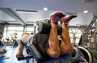 Image showing man flexing leg muscles on gym machine