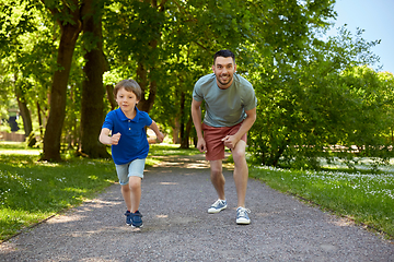 Image showing happy father and son compete in running at park