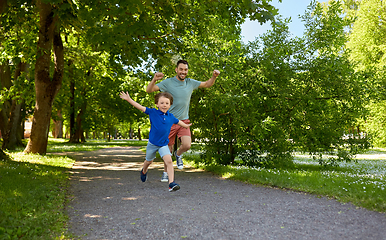 Image showing happy father and son compete in running at park