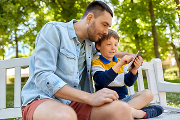 Image showing father and son with smartphone at park