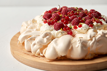 Image showing pavlova meringue cake with berries on wooden board