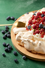 Image showing pavlova meringue cake with berries on wooden board