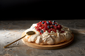 Image showing pavlova meringue cake with berries on wooden board