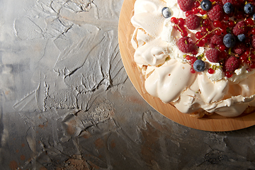 Image showing pavlova meringue cake with berries on wooden board