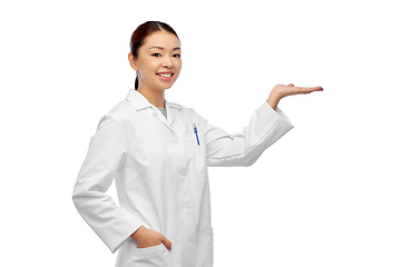 Image showing asian female doctor holding something on hand