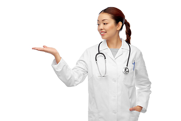 Image showing asian female doctor holding something on hand