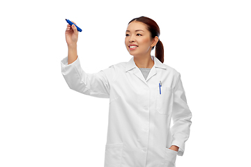 Image showing happy asian female doctor writing with blue marker