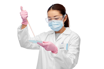 Image showing asian female scientist in mask working on vaccine