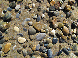 Image showing Wet sea pebbles on the sand