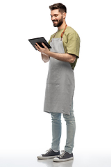 Image showing smiling waiter in apron with tablet pc computer