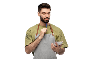 Image showing waiter in apron taking notes to notepad