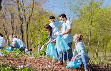 Image showing volunteers in masks with cleaning garbage at park