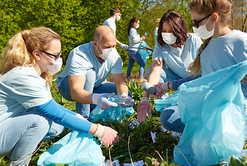 Image showing volunteers in masks with cleaning garbage at park